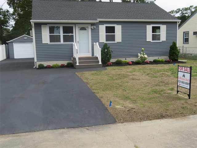 118 Muncy Ave, West Babylon, NY 11704 - view of front of house with an outbuilding, driveway, roof with shingles, a detached garage, and entry steps