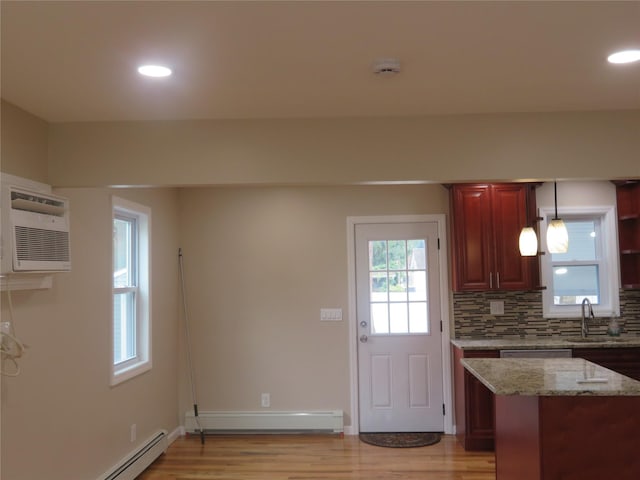 118 Muncy Ave, West Babylon, NY 11704 - kitchen featuring light wood finished floors, baseboard heating, a baseboard radiator, light stone counters, and an AC wall unit