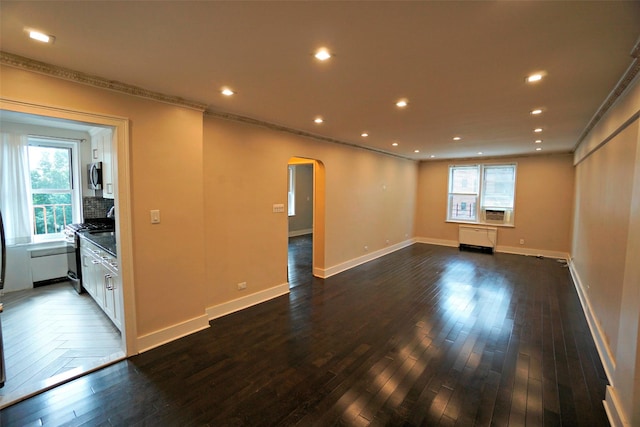 7281 113th St Unit 5F, Forest Hills, NY 11375 - empty room featuring arched walkways, ornamental molding, recessed lighting, dark wood-style floors, and healthy amount of natural light