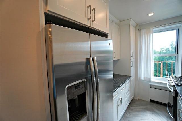7281 113th St Unit 5F, Forest Hills, NY 11375 - kitchen with stainless steel appliances, plenty of natural light, white cabinets, and dark stone countertops