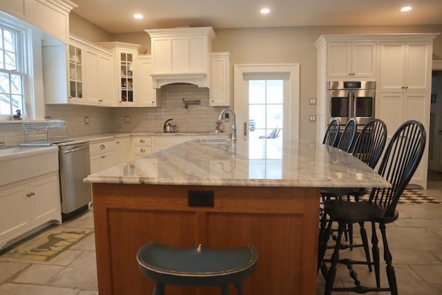 kitchen featuring stainless steel appliances, sink, a breakfast bar area, and a center island with sink