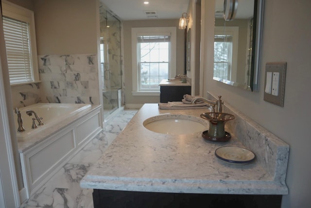 bathroom featuring vanity and independent shower and bath