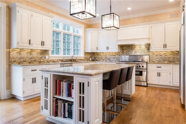 kitchen with white cabinets, high end stove, and a kitchen island