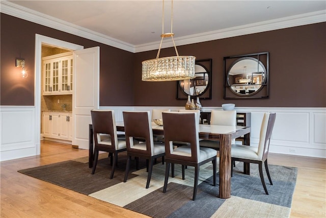 dining space featuring crown molding, hardwood / wood-style floors, and a chandelier