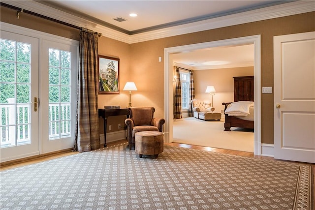 living area with wood-type flooring and ornamental molding