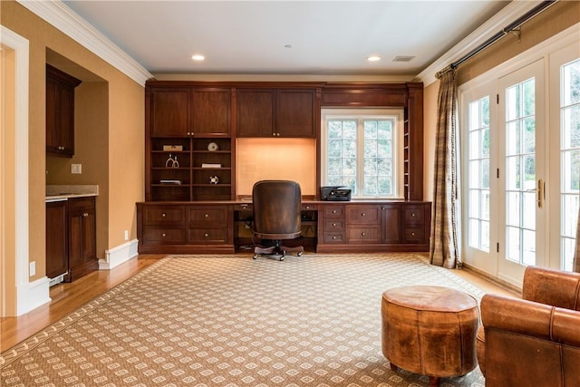 office space with crown molding, french doors, built in desk, and light hardwood / wood-style floors