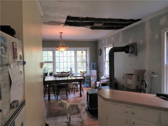 kitchen featuring white cabinetry, hardwood / wood-style floors, decorative light fixtures, and ornamental molding