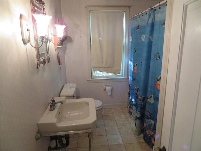 bathroom with tile patterned floors, curtained shower, sink, and toilet