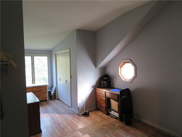 interior space with light hardwood / wood-style floors and vaulted ceiling