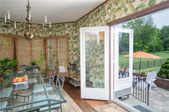 doorway to outside with wood-type flooring and ornamental molding