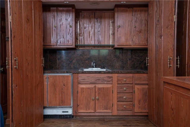 kitchen with dark hardwood / wood-style flooring, sink, and tasteful backsplash