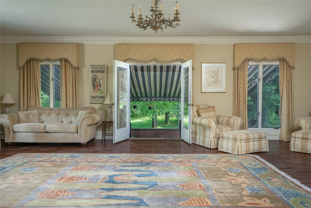 living room with crown molding, dark hardwood / wood-style floors, and an inviting chandelier