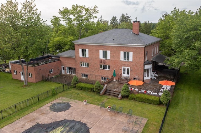 back of property with a yard and a patio area