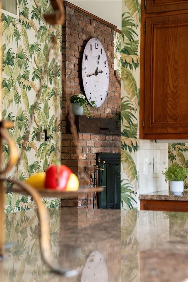 interior details with decorative backsplash and a brick fireplace