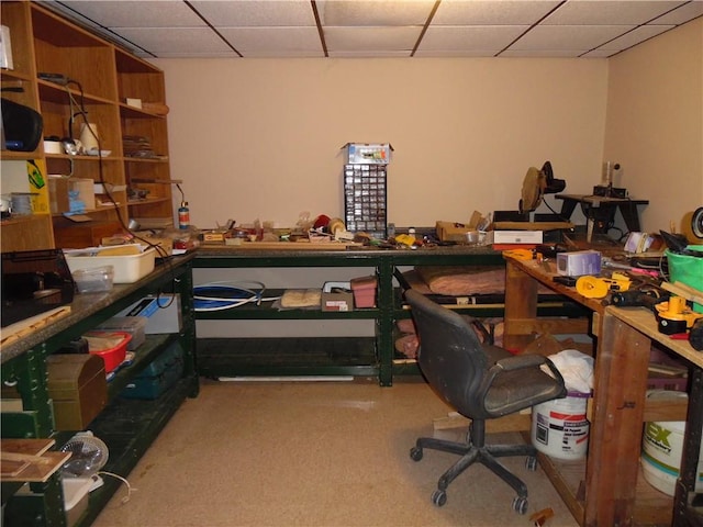 office space featuring a paneled ceiling, a workshop area, and carpet