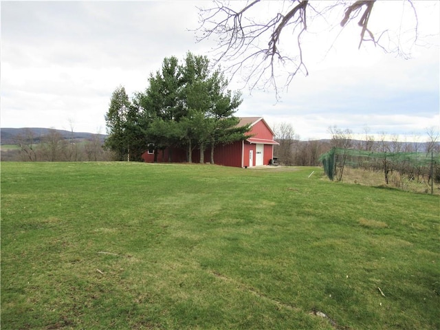 view of yard with an outbuilding and a rural view