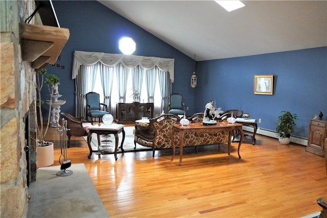 living room featuring light hardwood / wood-style floors, baseboard heating, a fireplace, and high vaulted ceiling