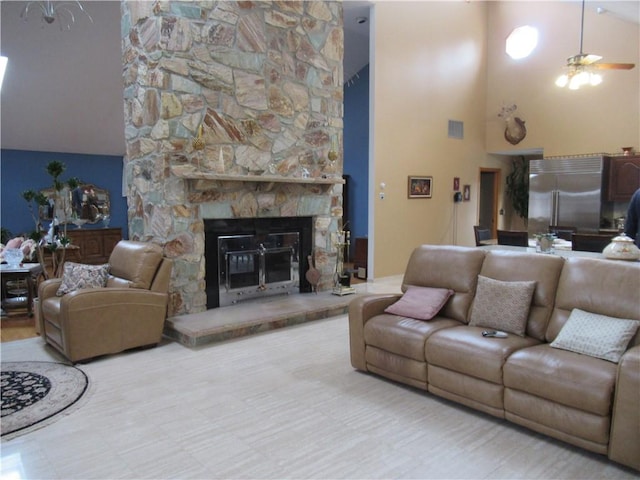 living room featuring ceiling fan, a fireplace, and high vaulted ceiling