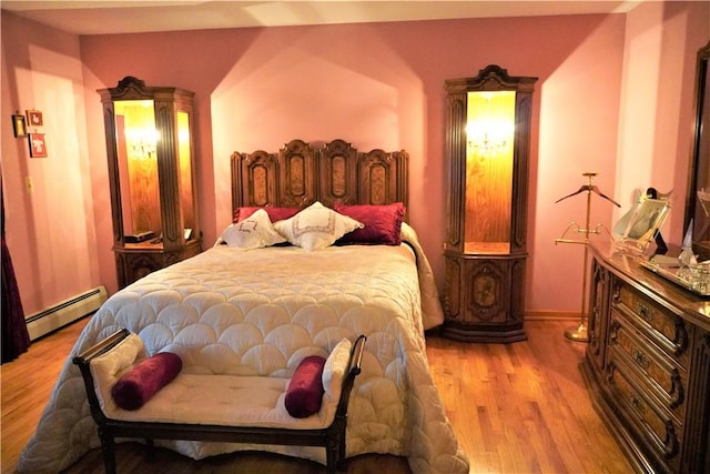 bedroom featuring light hardwood / wood-style flooring and a baseboard heating unit