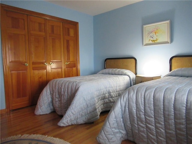 bedroom with hardwood / wood-style floors and a closet