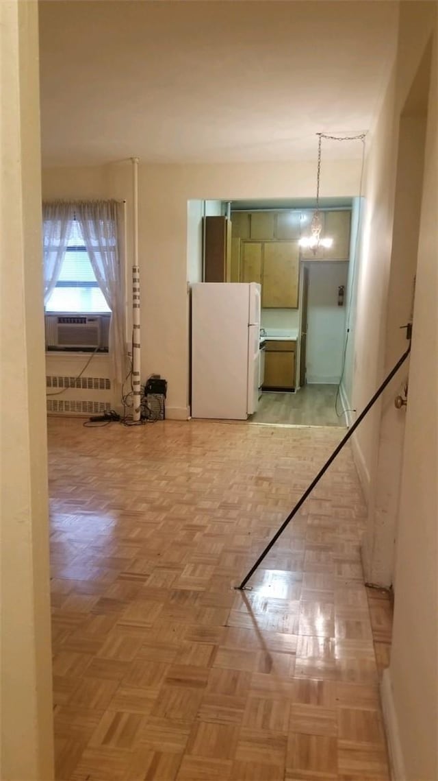 corridor featuring a chandelier, cooling unit, radiator heating unit, and light parquet floors