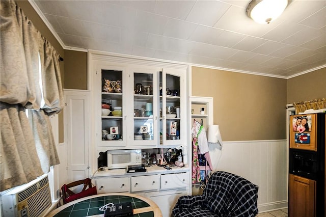 interior space with cooling unit, white cabinets, and ornamental molding