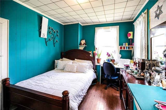 bedroom with crown molding and dark wood-type flooring