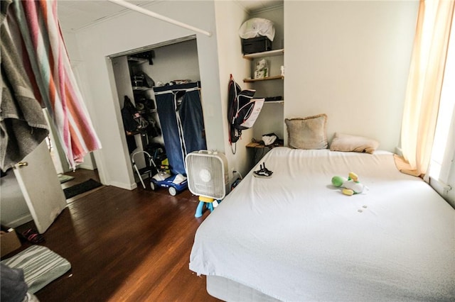 bedroom featuring crown molding, a closet, and dark wood-type flooring