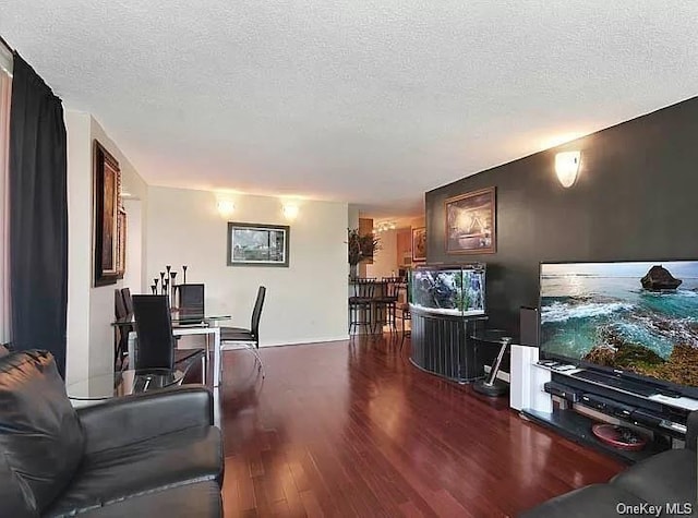 living room with dark wood-type flooring and a textured ceiling