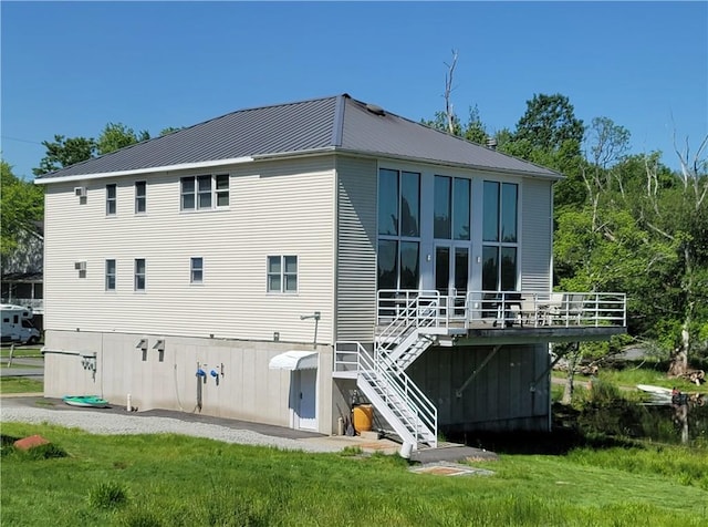 rear view of house featuring a lawn and a wooden deck