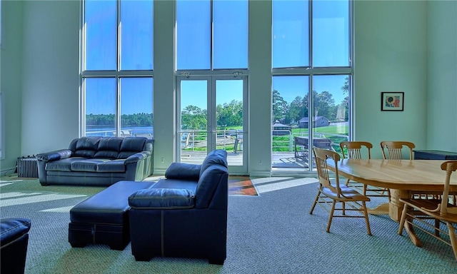 carpeted living room featuring a high ceiling