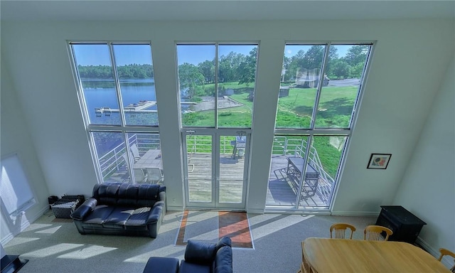 doorway to outside featuring a healthy amount of sunlight, a water view, and carpet floors