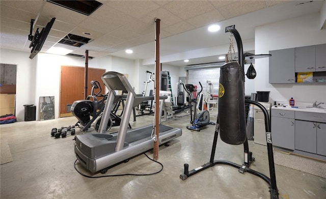 exercise room featuring a paneled ceiling and sink