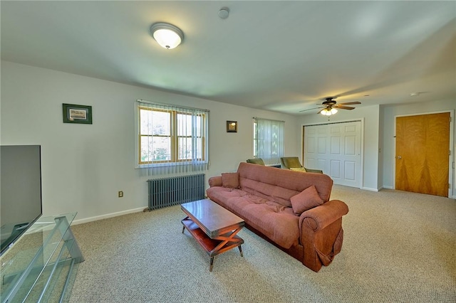 carpeted living room with radiator and ceiling fan