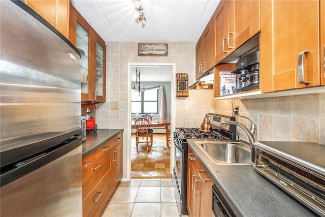 kitchen featuring backsplash, light tile patterned flooring, sink, and stainless steel appliances