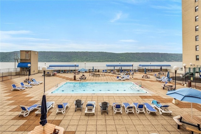 view of swimming pool featuring a patio area and a water view