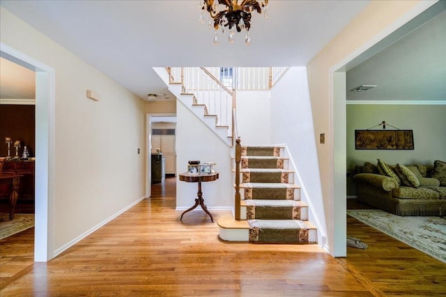 10 Evergreen Ct, Suffern, NY 10901 - staircase with wood finished floors, a chandelier, and baseboards