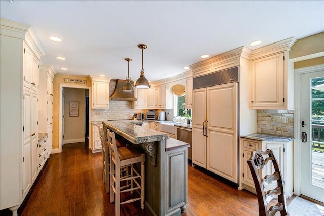 10 Evergreen Ct, Suffern, NY 10901 - kitchen with paneled refrigerator, wall chimney exhaust hood, a center island, tasteful backsplash, and decorative light fixtures