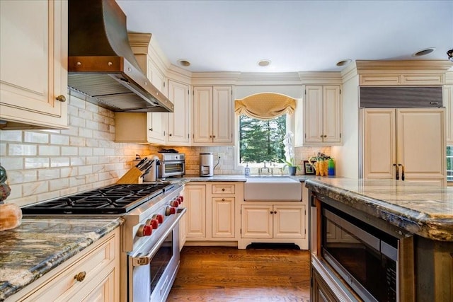 10 Evergreen Ct, Suffern, NY 10901 - kitchen featuring built in appliances, wall chimney exhaust hood, a sink, light stone counters, and cream cabinetry