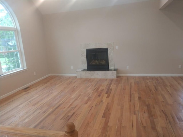 unfurnished living room with wood-type flooring and a tile fireplace