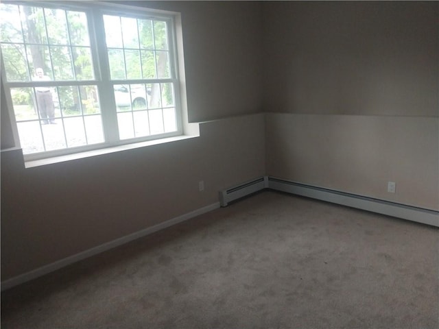 carpeted spare room featuring baseboard heating