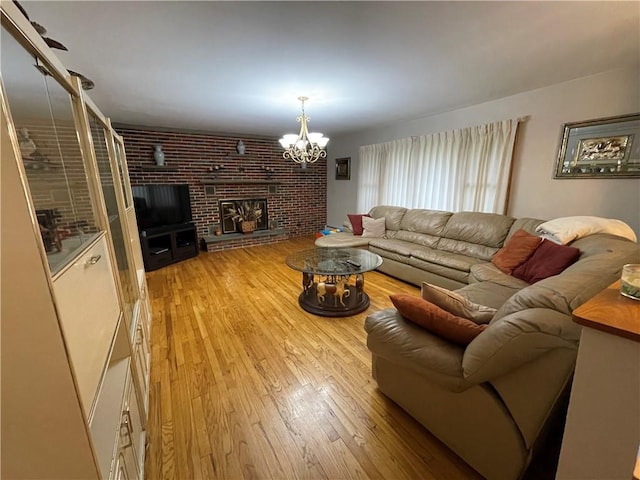 living room with a chandelier, light hardwood / wood-style floors, and a fireplace