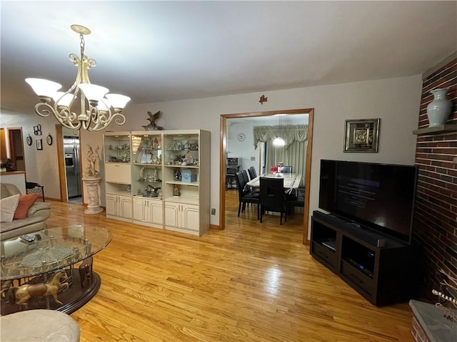 living room featuring a chandelier and light wood-type flooring