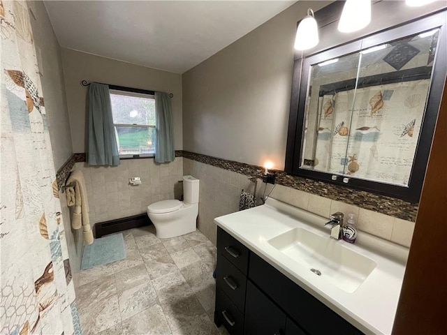 bathroom with vanity, a shower with shower curtain, toilet, tile walls, and a baseboard radiator