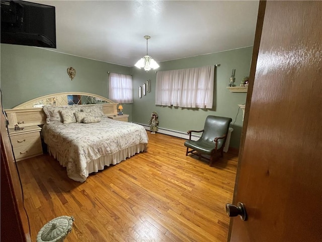 bedroom featuring a chandelier, light hardwood / wood-style floors, and baseboard heating