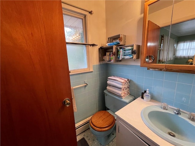 bathroom featuring baseboard heating, tile patterned flooring, toilet, vanity, and tile walls