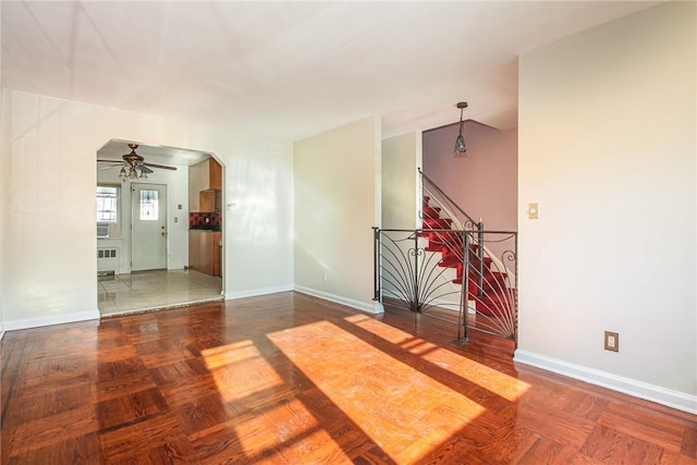 unfurnished room featuring ceiling fan, parquet flooring, and radiator heating unit