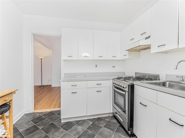 kitchen with stainless steel range, dark hardwood / wood-style flooring, white cabinetry, and sink