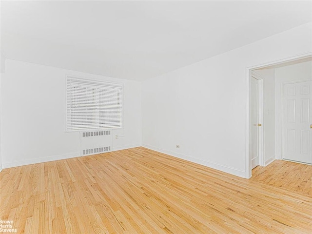 empty room featuring light hardwood / wood-style floors and radiator