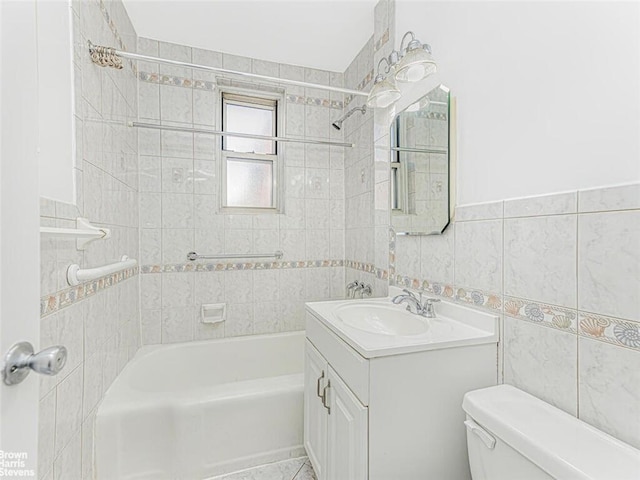 full bathroom with vanity, tiled shower / bath combo, tile walls, and toilet